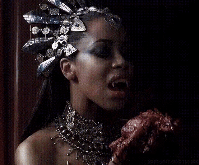 a woman in a crown is eating a piece of meat