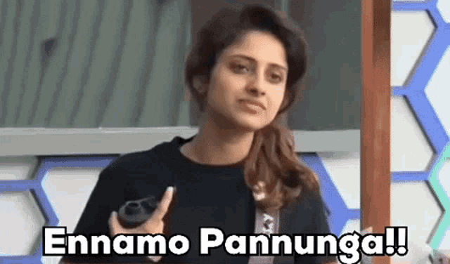 a woman is holding a camera in her hand and saying ennamo pannunga .