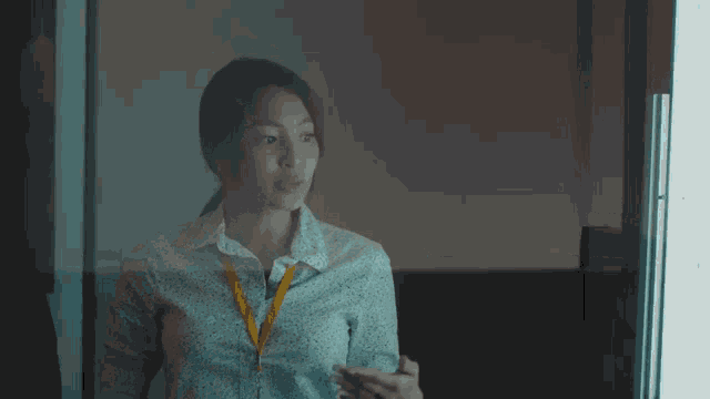 a woman with a lanyard around her neck looks at something