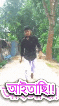 a man in a black shirt and white pants is walking down a road with a sign that says ' a '