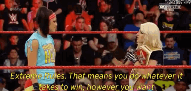 two women are in a wrestling ring and one of them is talking into a microphone