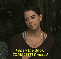 a woman is saying `` i open the door , completely naked '' while standing in front of a curtain .