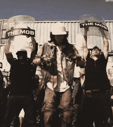 a group of people holding up riot shields with the mob written on them