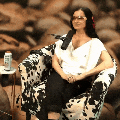 a woman sits in a chair with a microphone and a can of french roast on a table