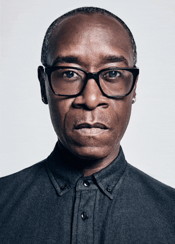 a close up of a man wearing glasses and a grey shirt