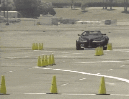 a car is driving through a parking lot with yellow cones