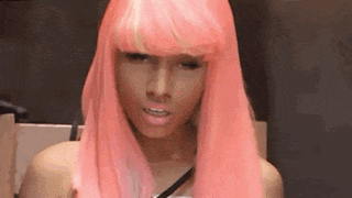 a close up of a woman wearing a pink wig with a yellow fringe .