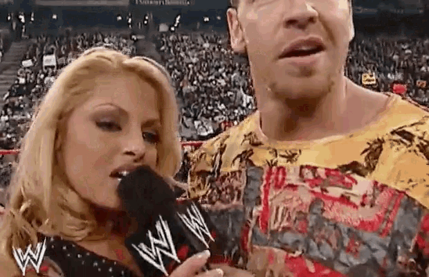 a woman is talking into a microphone while standing next to a man in front of a crowd .