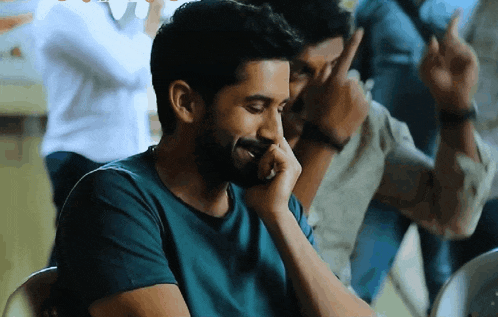 a man with a beard in a blue shirt is laughing