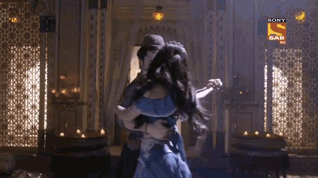 a man and a woman are dancing in front of a screen that says sony sab hi