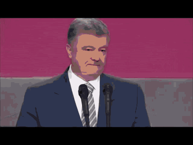 a man in a suit and tie is giving a speech
