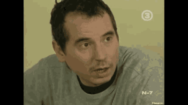 a man in a grey shirt with the number 3 on the bottom right