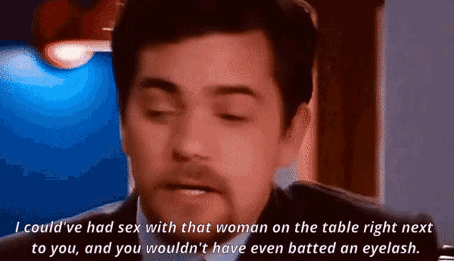 a man in a suit is talking about sex with a woman