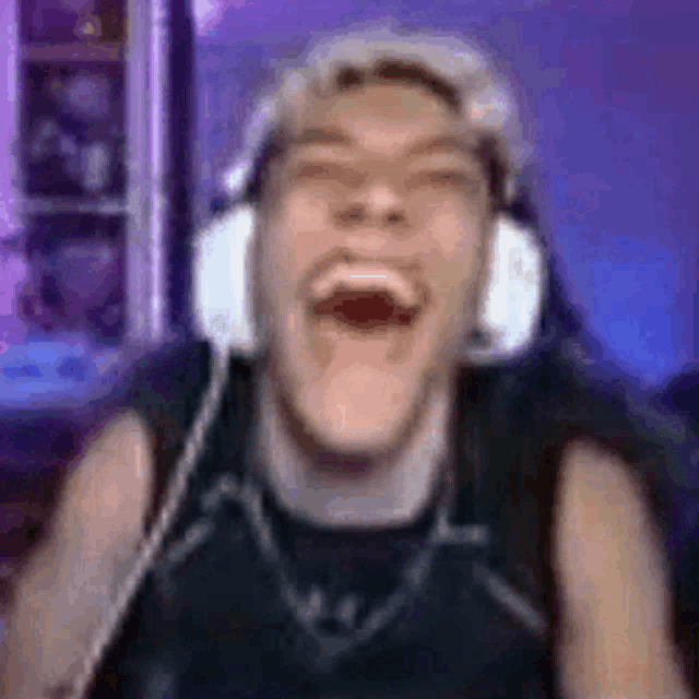 a man wearing headphones is making a funny face while laughing .