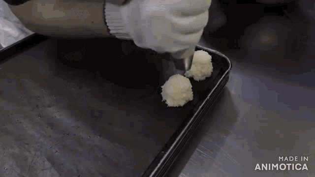 a person is holding a piping bag over a tray that says made in animonica