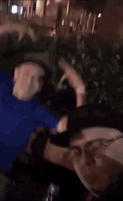 a blurry picture of two people standing next to each other in front of a tree