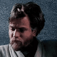 a close up of a man with a beard wearing a sweater and a robe .