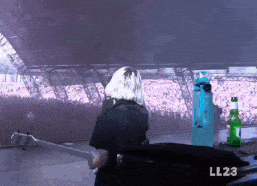 a woman stands in front of a crowd with the number ll23 on the bottom right