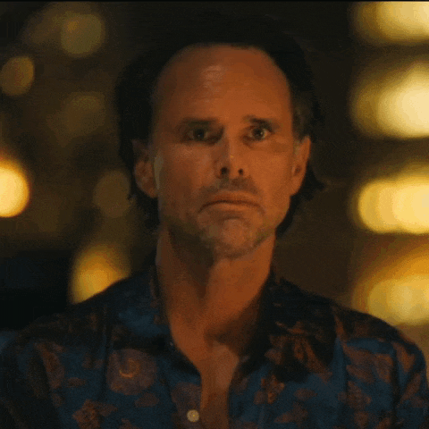a close up of a man 's face in a blue shirt