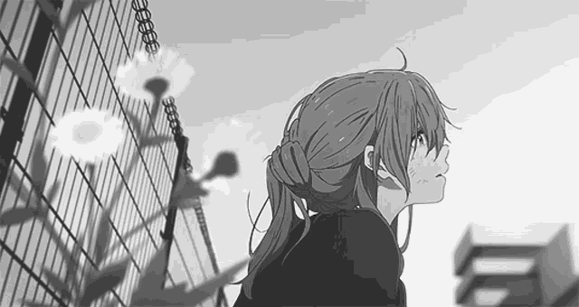 a black and white photo of a girl standing next to a fence .