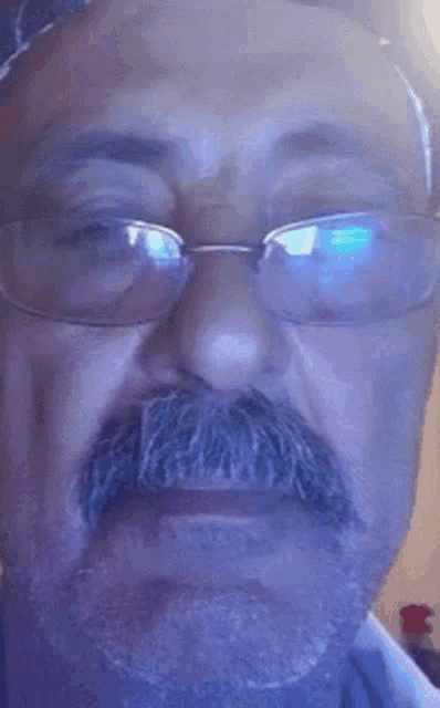 a close up of a man 's face with glasses and a beard