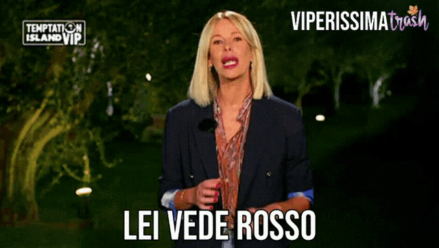 a woman stands in front of temptation island vip