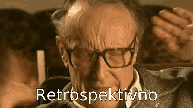 an elderly man wearing glasses is sitting in a chair with the words retrospektivno written above him