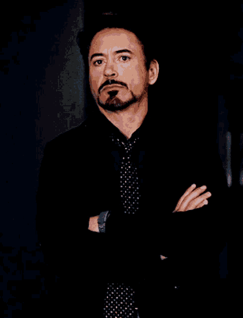 a man with a beard and mustache wearing a black suit and tie