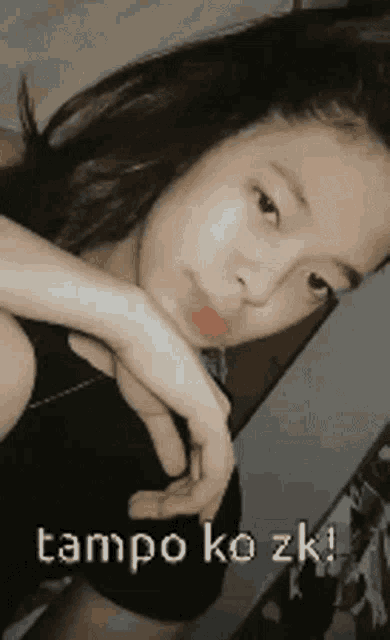 a young girl is taking a selfie with the words tampo ko zk written on the bottom