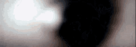 a close up of a person 's face in the dark with a light coming out of it .