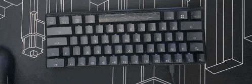 a black keyboard is sitting on top of a black and white geometric mat