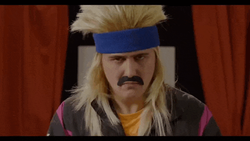 a man wearing a wig and a blue headband with a mustache