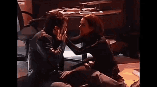 a man and a woman are sitting next to each other on the floor .