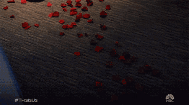 red rose petals are scattered on the floor with a nbc logo in the corner