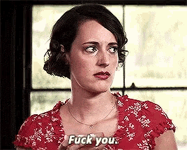 a woman in a red dress is holding a glass and saying fuck you .