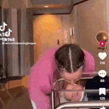a woman is kissing a baby in a crib in a room .