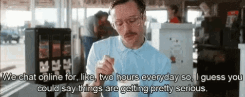 a man with glasses and a mustache is eating ice cream with a spoon in a restaurant .
