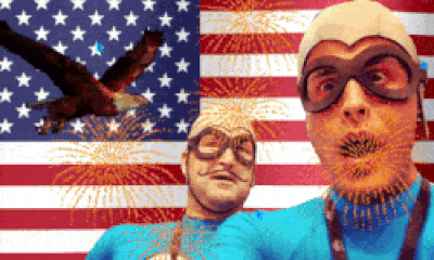 a man in a superhero costume stands in front of an american flag and fireworks