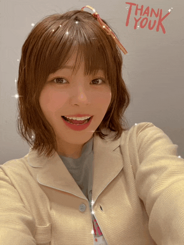 a woman is taking a selfie with the words thank youk written on the wall behind her