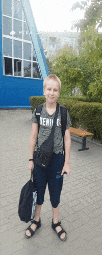 a boy with a backpack and a shirt that says deni on it