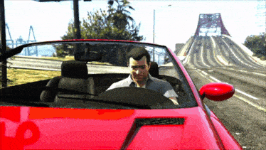 a man is sitting in a red car with the number 7 on the hood
