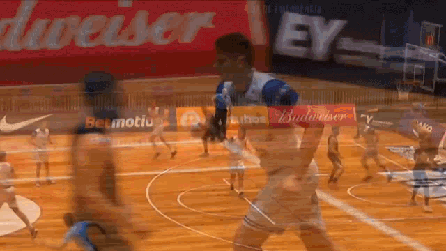 a blurry picture of a basketball game with a budweiser advertisement in the background