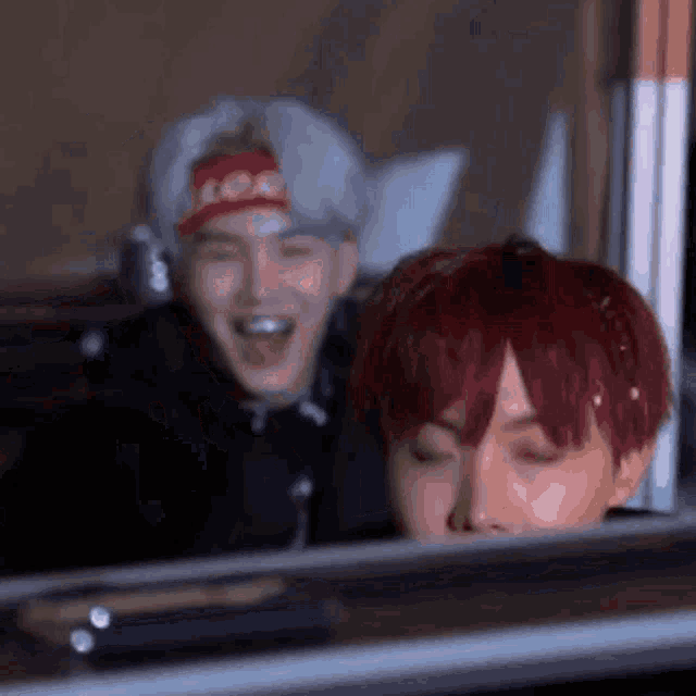a man with red hair is laughing while another man with white hair is laughing .