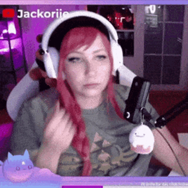 a woman with red hair is sitting in front of a microphone and headphones .