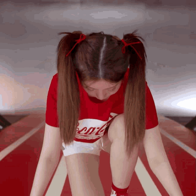 a girl wearing a red shirt that says coca cola on it