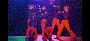 a group of people are standing next to each other on a stage in a dark room .