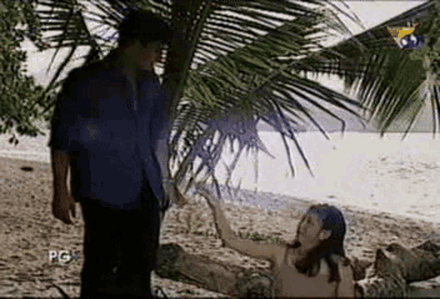 a man and a woman are standing next to each other on a beach .