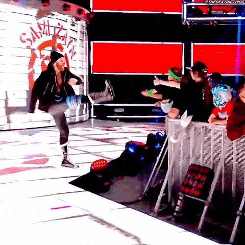 a wrestler is kicking a fan in front of a wall that says smackdown