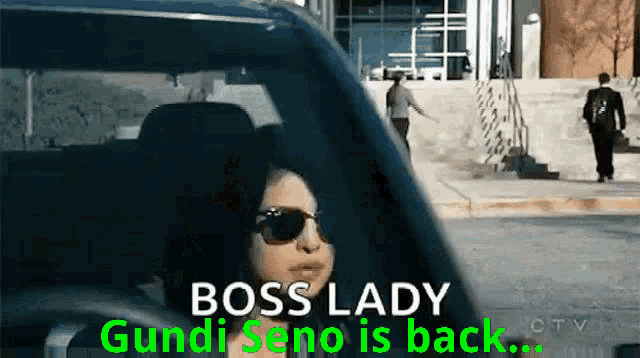 a woman wearing sunglasses is driving a car and says boss lady gundu seno is back ..