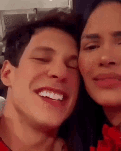 a man and a woman are smiling for the camera .
